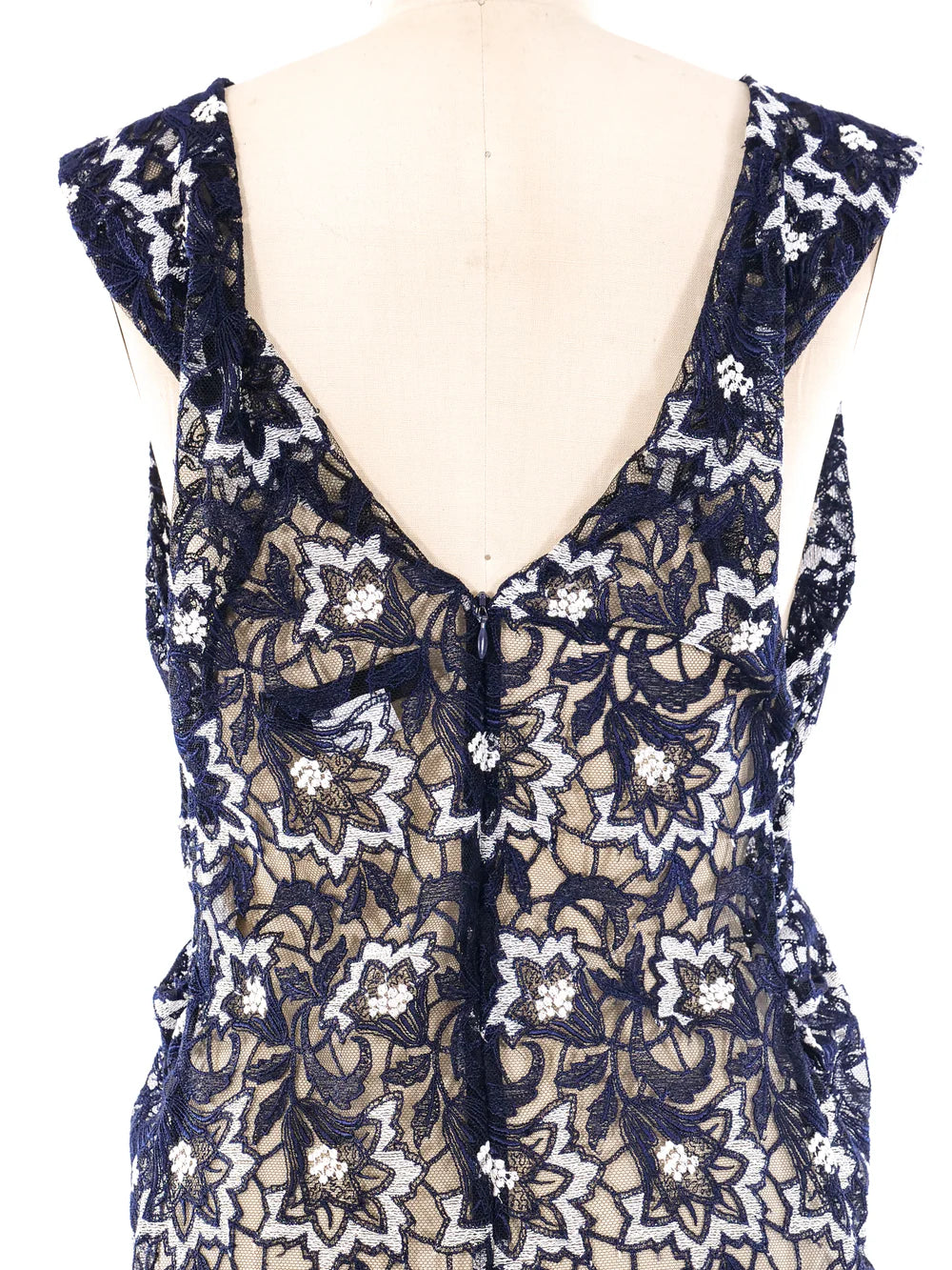 Navy blue lace top with floral patterns on a mannequin